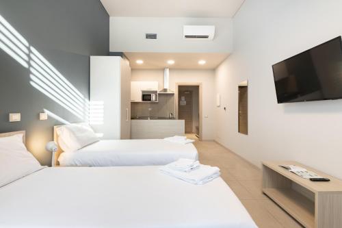 two beds in a room with a tv on a wall at Camplus Regio Parco in Turin