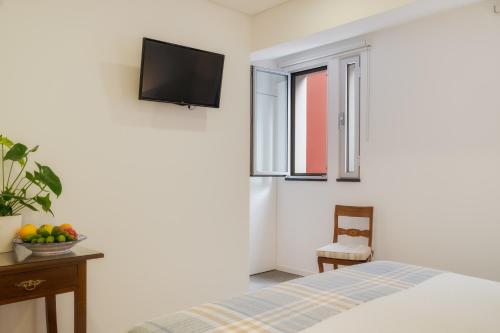 a bedroom with a bed and a tv on the wall at Casa da Praça Double room - by Casas na Ilha in Funchal
