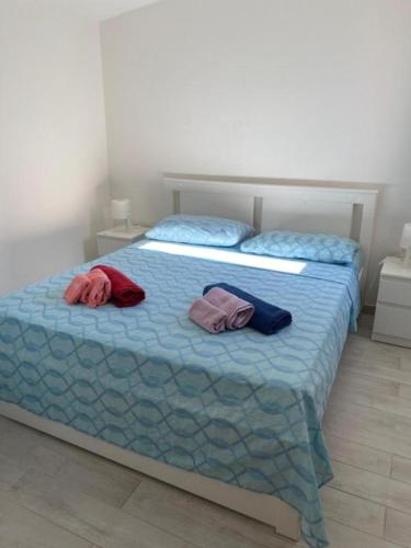 een slaapkamer met een bed met twee handdoeken erop bij Appartamento sul mare Scoglitti 2 in Scoglitti