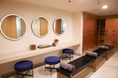 a dressing room with three mirrors on the wall at Andaz Condesa Mexico City, By Hyatt in Mexico City