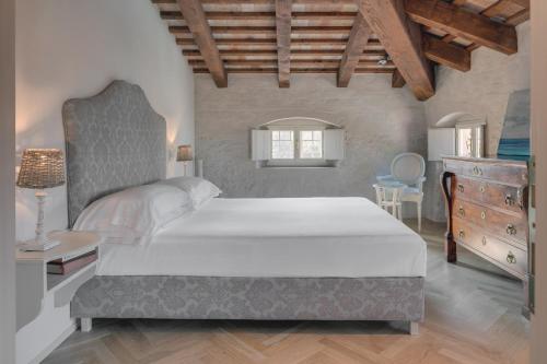 sypialnia z dużym białym łóżkiem i drewnianym sufitem w obiekcie Rambaldi Apartments Casa nr 5 w mieście Bardolino