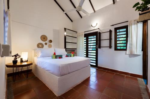 a bedroom with a large white bed and a table at La Mello Country House in Palomino