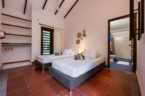 two beds in a room with white walls at La Mello Country House in Palomino