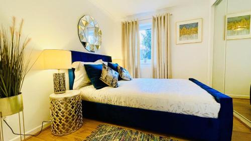 1 dormitorio con cama azul y espejo en Sunshine Place St. Albans, en Saint Albans