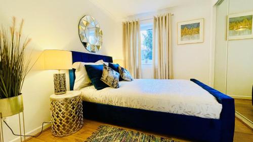 a bedroom with a blue bed and a mirror at Sunshine Place St. Albans in Saint Albans