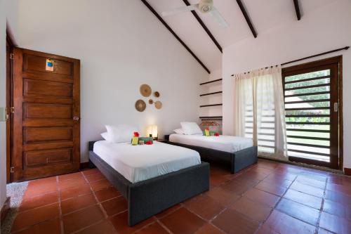 a bedroom with two beds and a door at La Mello Adventure Lodge in Palomino