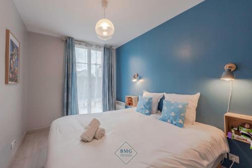 1 dormitorio con 1 cama blanca grande y paredes azules en Toy story apartment Disneyland Bmyguest, en Chessy