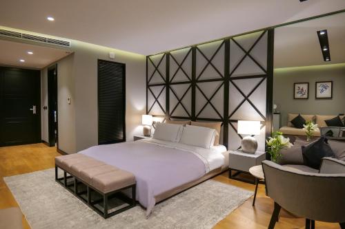 a bedroom with a large bed and two chairs at Hotel Miramare in Vlorë