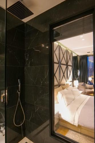 a bathroom with a mirror and a bed in a room at Hotel Miramare in Vlorë