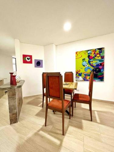 a dining room with a table and chairs and a painting at Moderno Apto con Vista a la Basílica in Buga