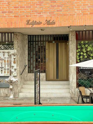 a building with a front door with a table and an umbrella at Moderno Apto con Vista a la Basílica in Buga