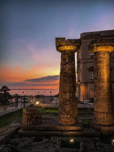 two stone columns in front of a building at sunset at L’angolo rosa in Carosino