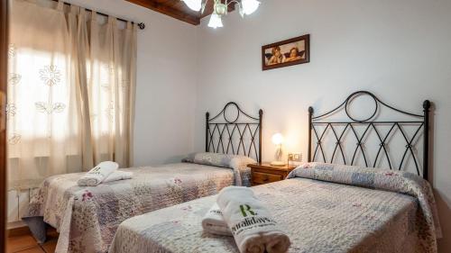 ein Schlafzimmer mit 2 Betten und Handtüchern darauf in der Unterkunft Casa Rural La Ventilla Arbuniel by Ruralidays in Jaén