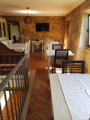 a dining room with tables and chairs and a tv at Trebid'Ouro in Vale de Cambra