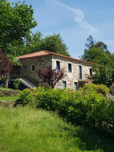 a stone building with a staircase in a field at Trebid'Ouro in Vale de Cambra