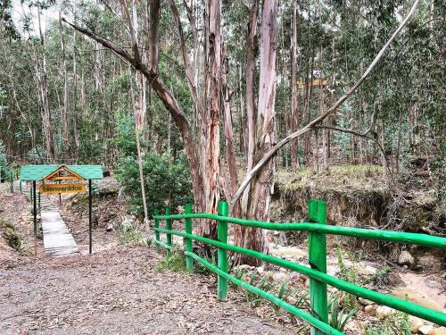 a green fence next to a path in a forest at Domos Sup3r López in Pesca
