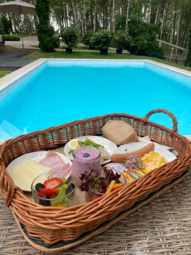 - un panier de nourriture à côté de la piscine dans l'établissement Dwór Złotopolska Dolina Mansion House, à Trębki