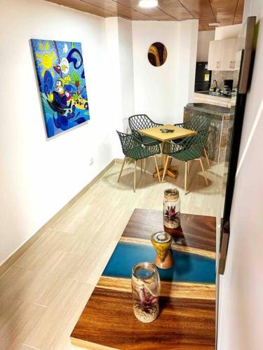 a room with a table and chairs and a painting on the floor at Hermoso Apto Con Vista a la Basílica in Buga