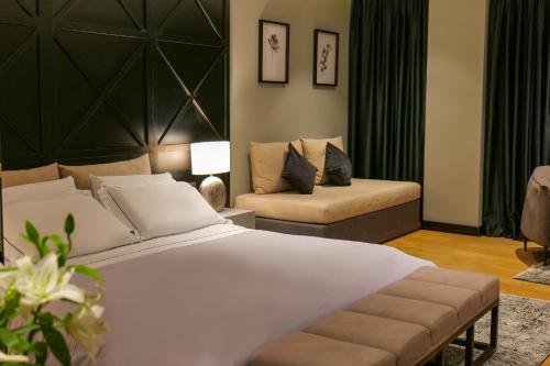 a bedroom with a large white bed and a couch at Hotel Miramare in Vlorë