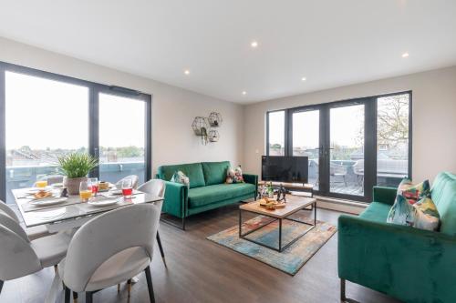 a living room with green furniture and a table at Elliot Oliver - Stunning Three Bedroom Penthouse With Large Terrace & Parking in Gloucester