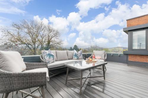 a patio with two chairs and a table on a deck at Elliot Oliver - Stunning Three Bedroom Penthouse With Large Terrace & Parking in Gloucester