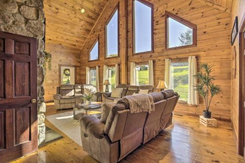 a living room with leather furniture and windows at Pool, Games and Sauna Mount Joy Countryside Cabin in Mount Joy