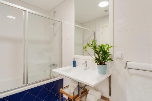 ein Badezimmer mit einem weißen Waschbecken und einem Spiegel in der Unterkunft Casa da Praça Apartments - by Casas na Ilha in Funchal