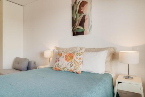um quarto com uma cama com uma almofada e uma cadeira em Casa da Praça Apartments - by Casas na Ilha em Funchal