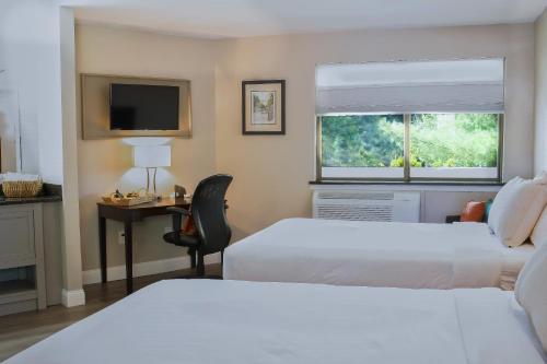 a hotel room with two beds and a desk and a window at Align Inn Vermont in Quechee