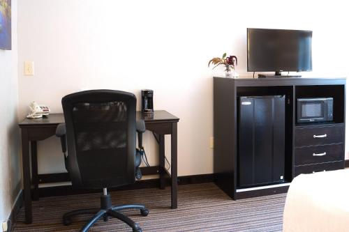 a room with a desk and a chair and a television at Align Inn Vermont in Quechee