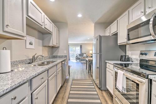 a kitchen with white cabinets and a stainless steel refrigerator at Branson Condo with Balcony Near Silver Dollar City in Branson