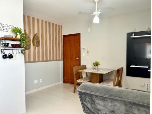 a living room with a table and a television at Hotel APART Zuccolotto 201 in Aracruz
