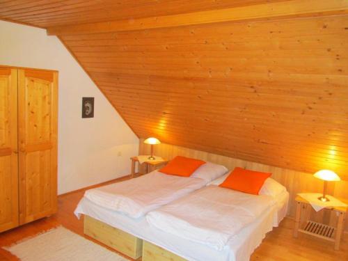 a bedroom with a bed with two orange pillows at Holiday House Maluzina Low Tatras in Malužiná