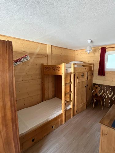 a cabin with two bunk beds in a room at Babaute 7, studio typique au pied des pistes in Prémanon