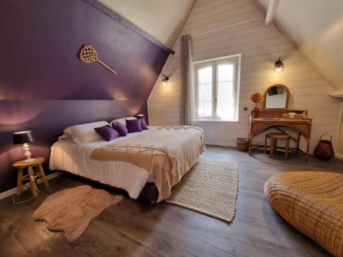a bedroom with a large bed with purple walls at Le Domaine du Terroir à 5 minutes des Grottes de Lascaux in La Chapelle-Aubareil