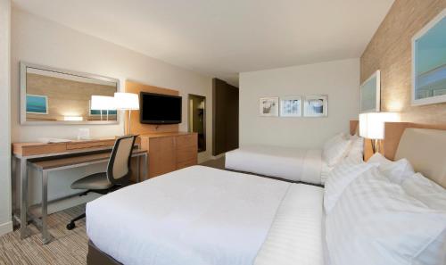 a hotel room with two beds and a desk and a computer at Holiday Inn Washington-Central/White House by IHG in Washington