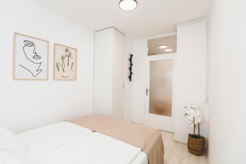 a white bedroom with a bed and a window at Comfy Place in Trešnjevka with FREE parking in Zagreb