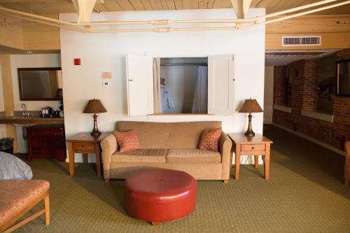 a living room with a couch and a red stool at The Common Man Inn & Restaurant in Claremont