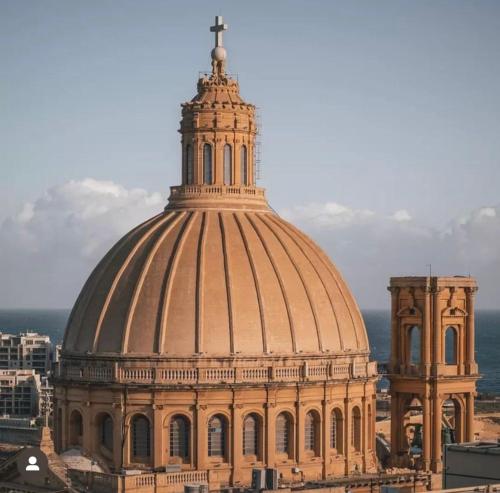 a large building with a cross on top of it at MCC Suites Valletta in Valletta