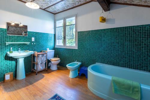 ein Badezimmer mit einer blauen Badewanne, einem WC und einem Waschbecken in der Unterkunft Chalet des Melezes in Font Romeu Odeillo Via