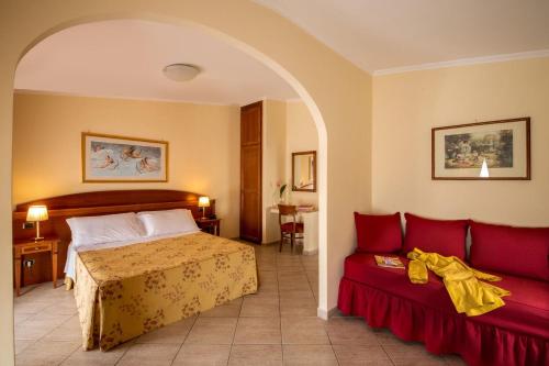 Habitación de hotel con cama y sofá en Marini Park Hotel, en Castel di Leva