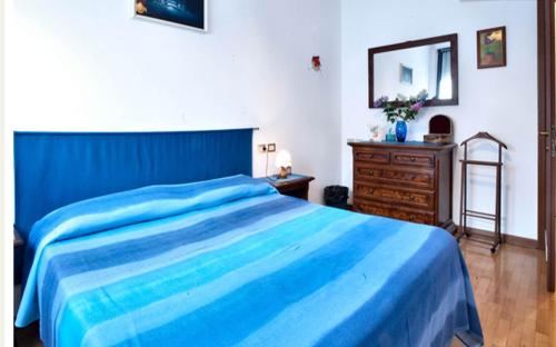 a bedroom with a blue bed and a wooden dresser at Il Giacinto in Milan