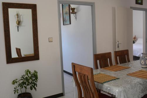 a dining room with a table and a mirror at Latifa house in Oualidia