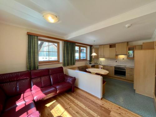 ein Wohnzimmer mit einem Sofa und einer Küche in der Unterkunft Abelhof in Schladming