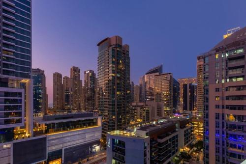 a city skyline at night with tall buildings at Vacationer Holiday Homes I Stunning 4 Bed I 10 Min from Marina Mall in Dubai