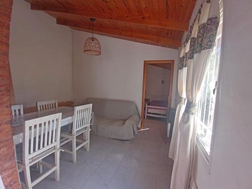 sala de estar con mesa, sillas y sofá en Quinta El Cholito en Luján