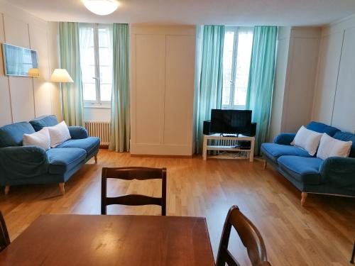 a living room with blue couches and a table at Gasthof zur Waag in Bad Zurzach