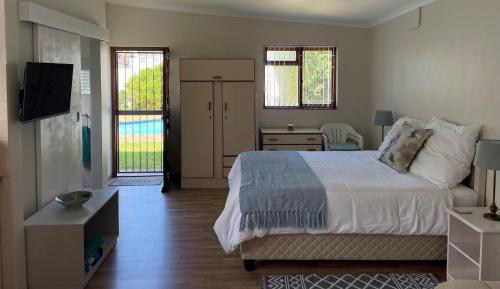 1 dormitorio con 1 cama y TV en Bob-Bob's Cottage en Ciudad del Cabo