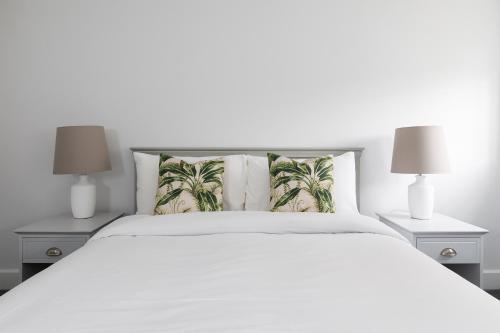 - une chambre avec un lit blanc et 2 lampes dans l'établissement Cloisters Cottage, à Chichester