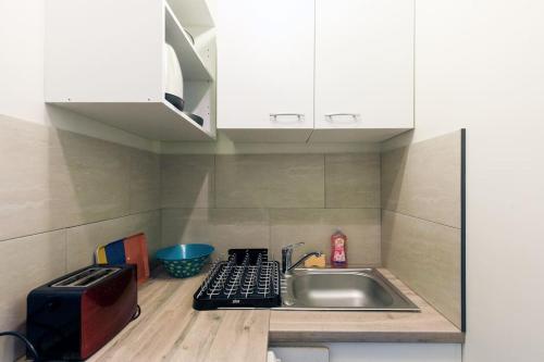 une petite cuisine avec un évier et une cuisinière dans l'établissement Perle Rare Cannes Centre Croisette Hôtel Carlton 1mn des Plages 5mn Palais, à Cannes